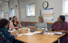 Four women at a table in a meeting, engaged in discussion about CCAP.

